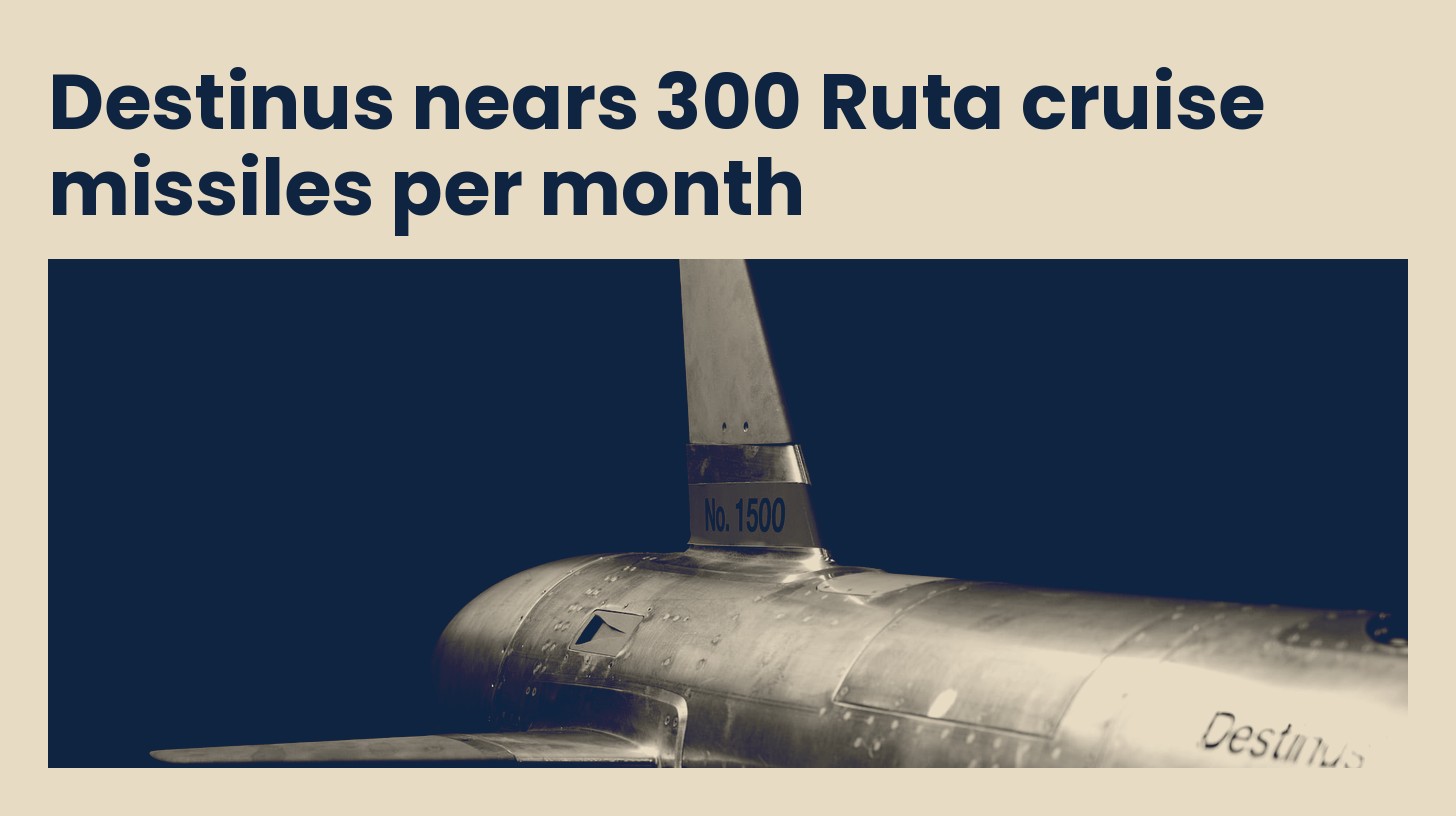 Close view of the tail and bare metal fuselage of a Destinus Ruta B1 cruise missile, in navy and sand tones.