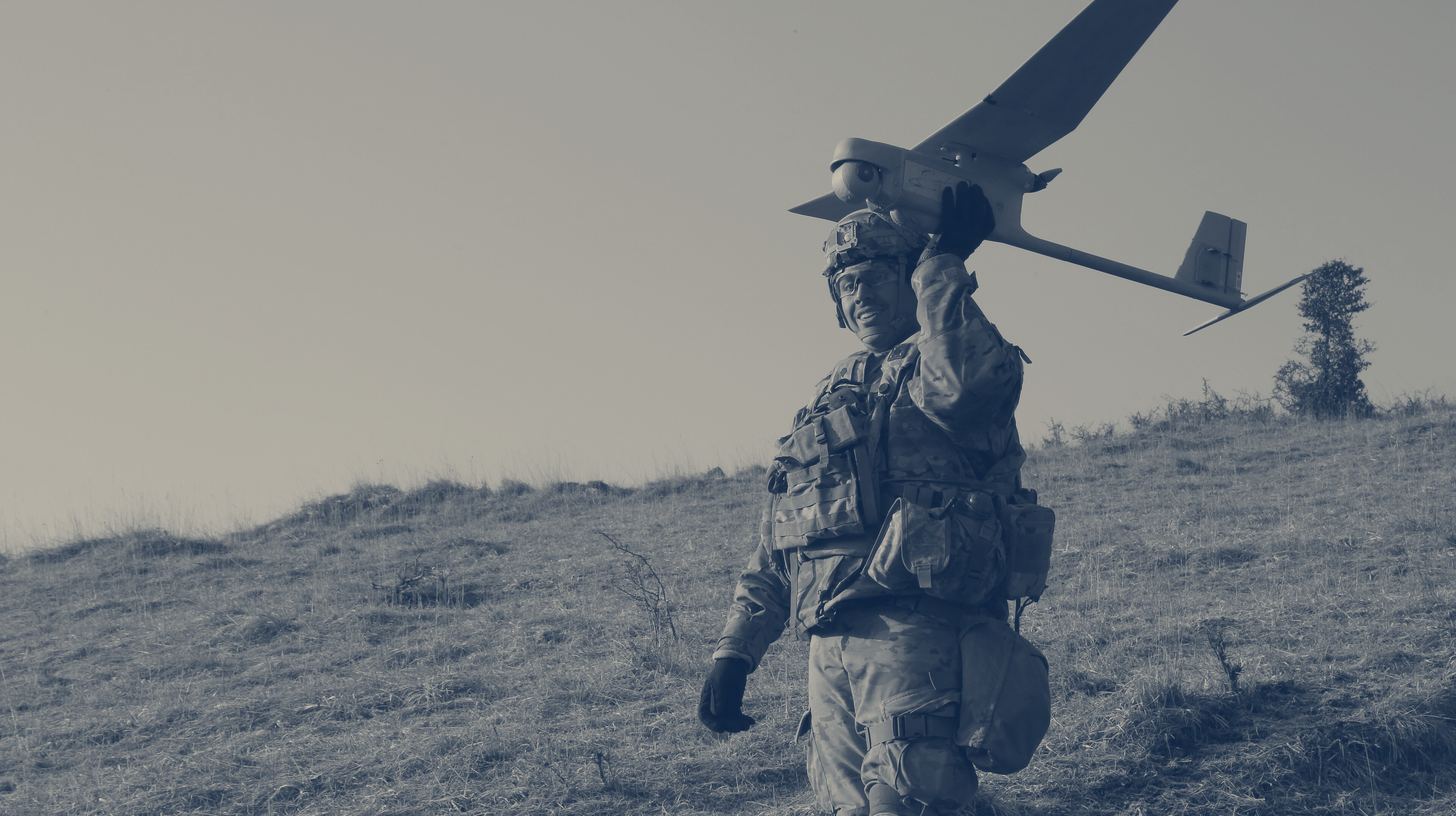 Two-tone U.S. Army photo of a 2nd Cavalry Regiment soldier holding up an RQ-11 Raven small drone to launch it at Hohenfels Training Area, Germany, April 2021.