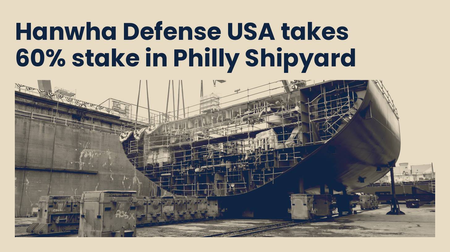 A ship hull section on transporters in the dry dock at Hanwha Philly Shipyard, in navy and sand tones.