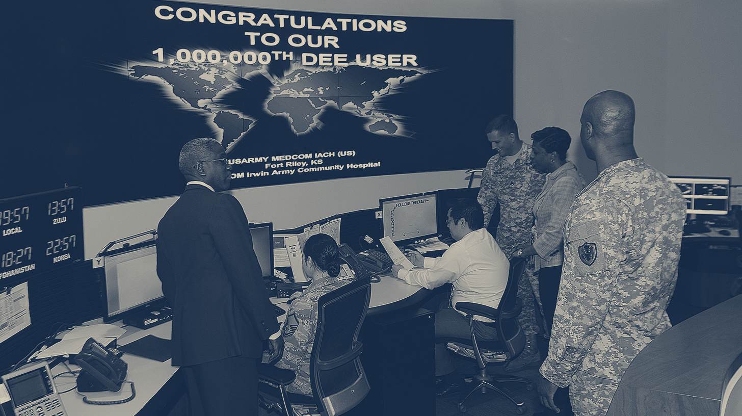 Two-tone DoD photo of staff in the Defense Information Systems Agency command center at Fort Meade, Maryland, in front of a global network display, March 2013.