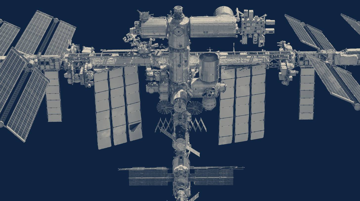 Two-tone NASA photo of the International Space Station against black space, taken from a Crew Dragon during a 2021 flyaround.
