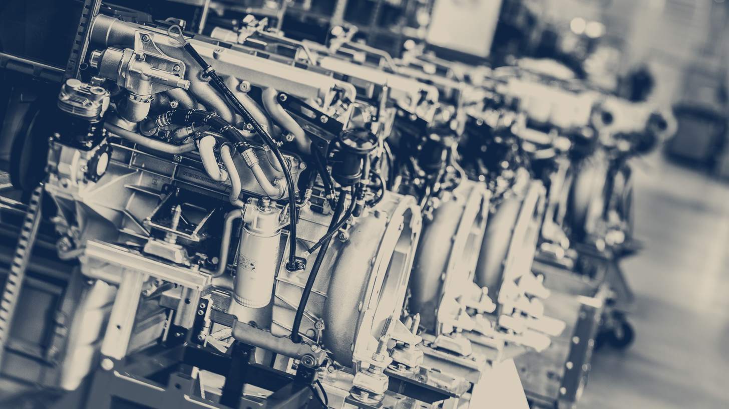 Two-tone Steyr Motors company photo of a row of Steyr compact diesel engines on assembly stands.