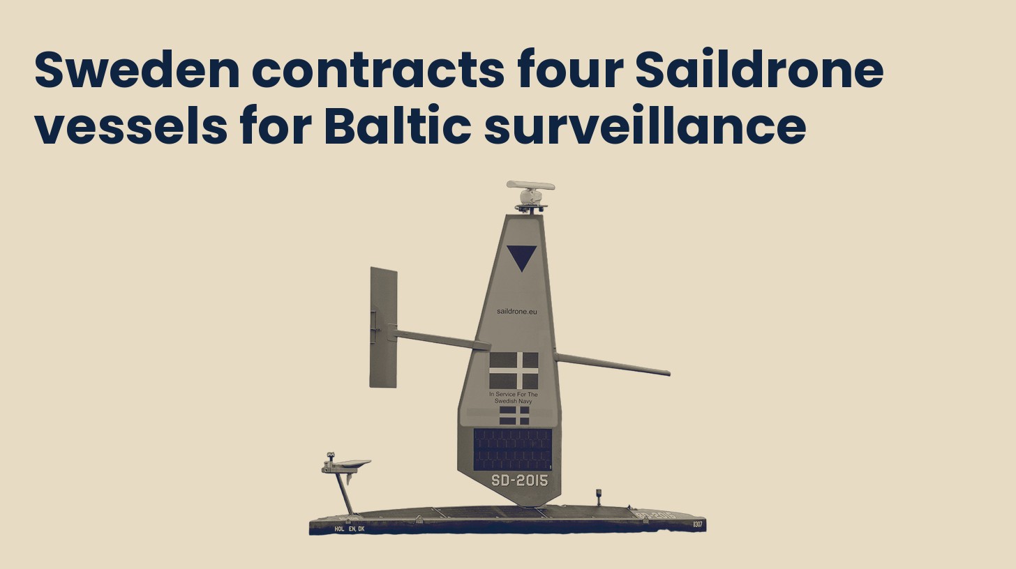 A Saildrone Voyager uncrewed surface vessel with Danish and Swedish flags on its orange sail, isolated on a plain sand background.