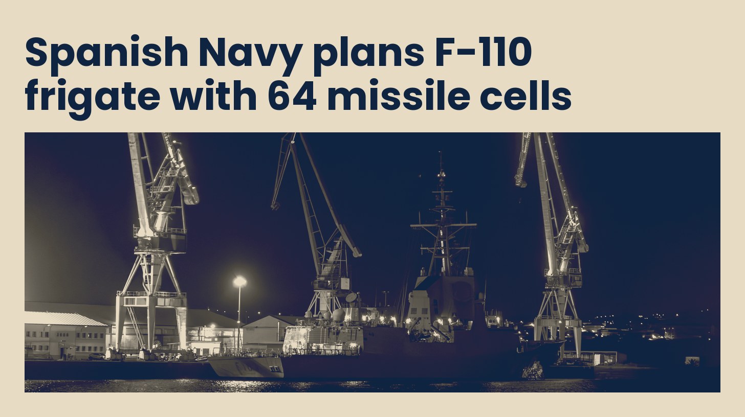An F-110 frigate alongside the quay under shipyard cranes at Navantia Ferrol at night.