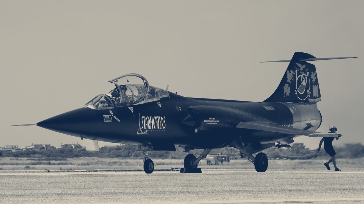 Two-tone photo of the Starfighters Aerospace TF-104G-M Starfighter N991SF on the runway at Pratica di Mare, Italy, June 2023.