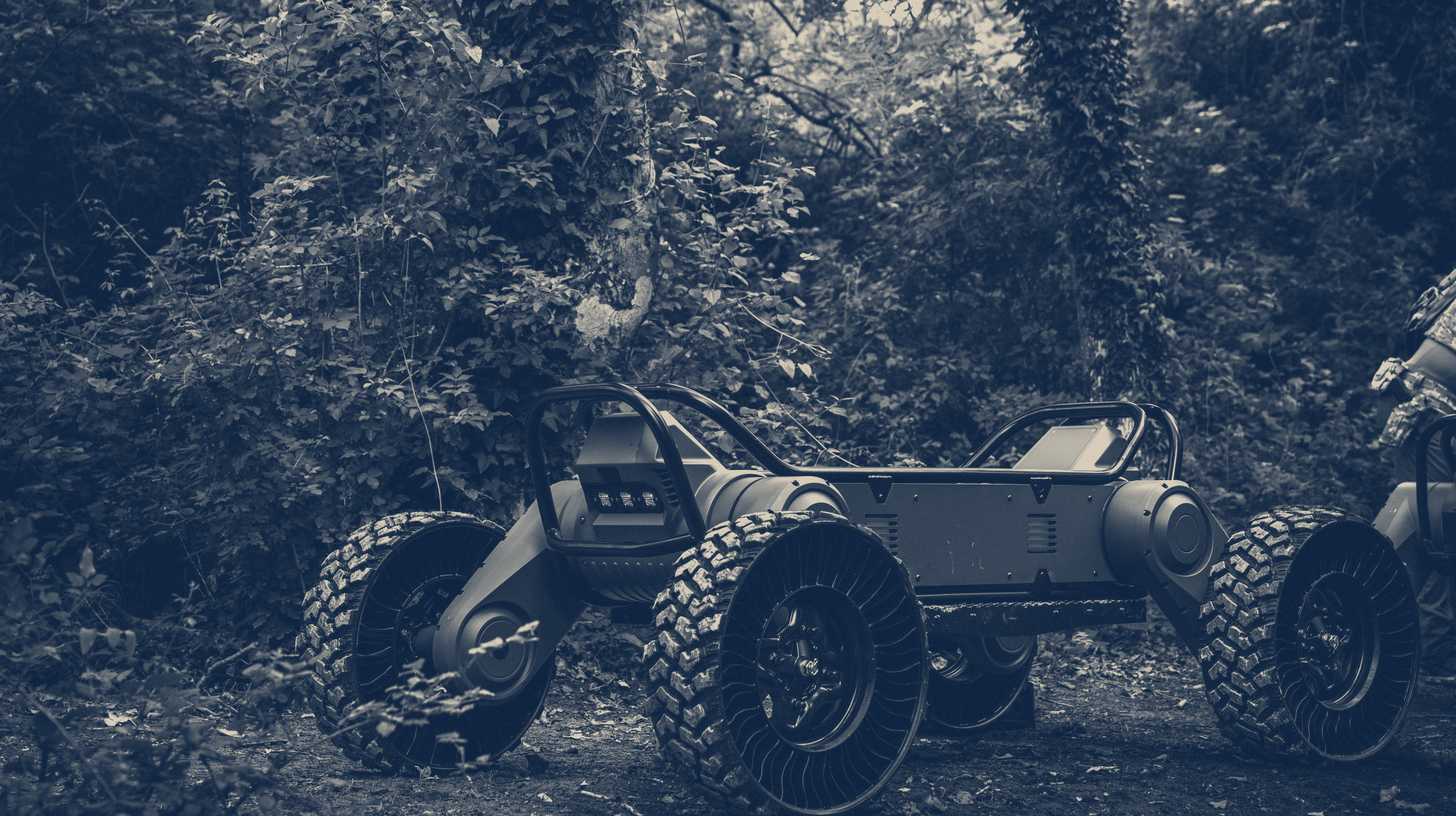 Two-tone Stratonex concept rendering, not a photograph, of the VARAN modular uncrewed ground vehicle in a forest.
