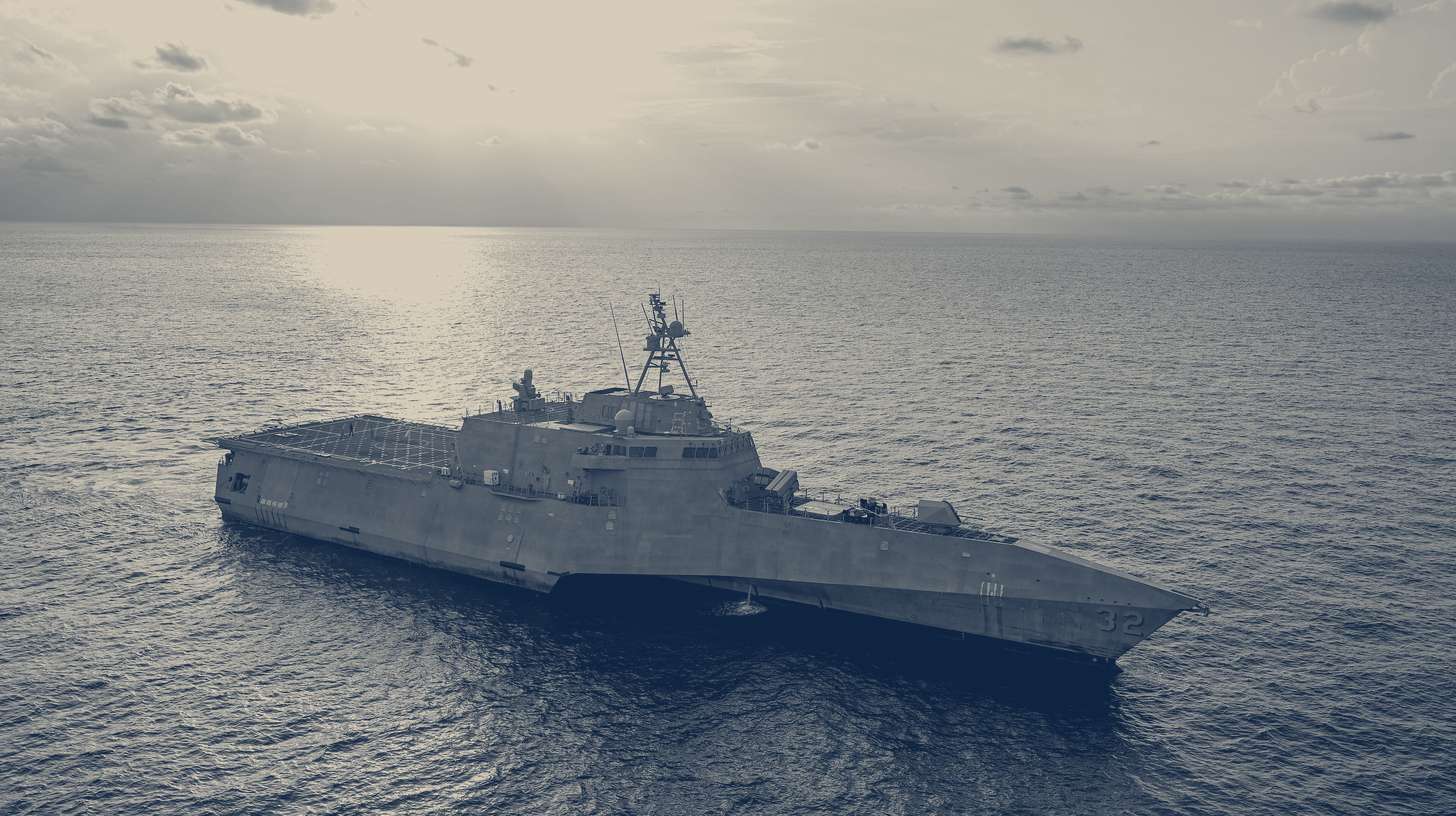 Two-tone U.S. Navy photo of the littoral combat ship USS Santa Barbara under way in the Arabian Gulf during a LUCAS one-way attack drone launch, December 2025.