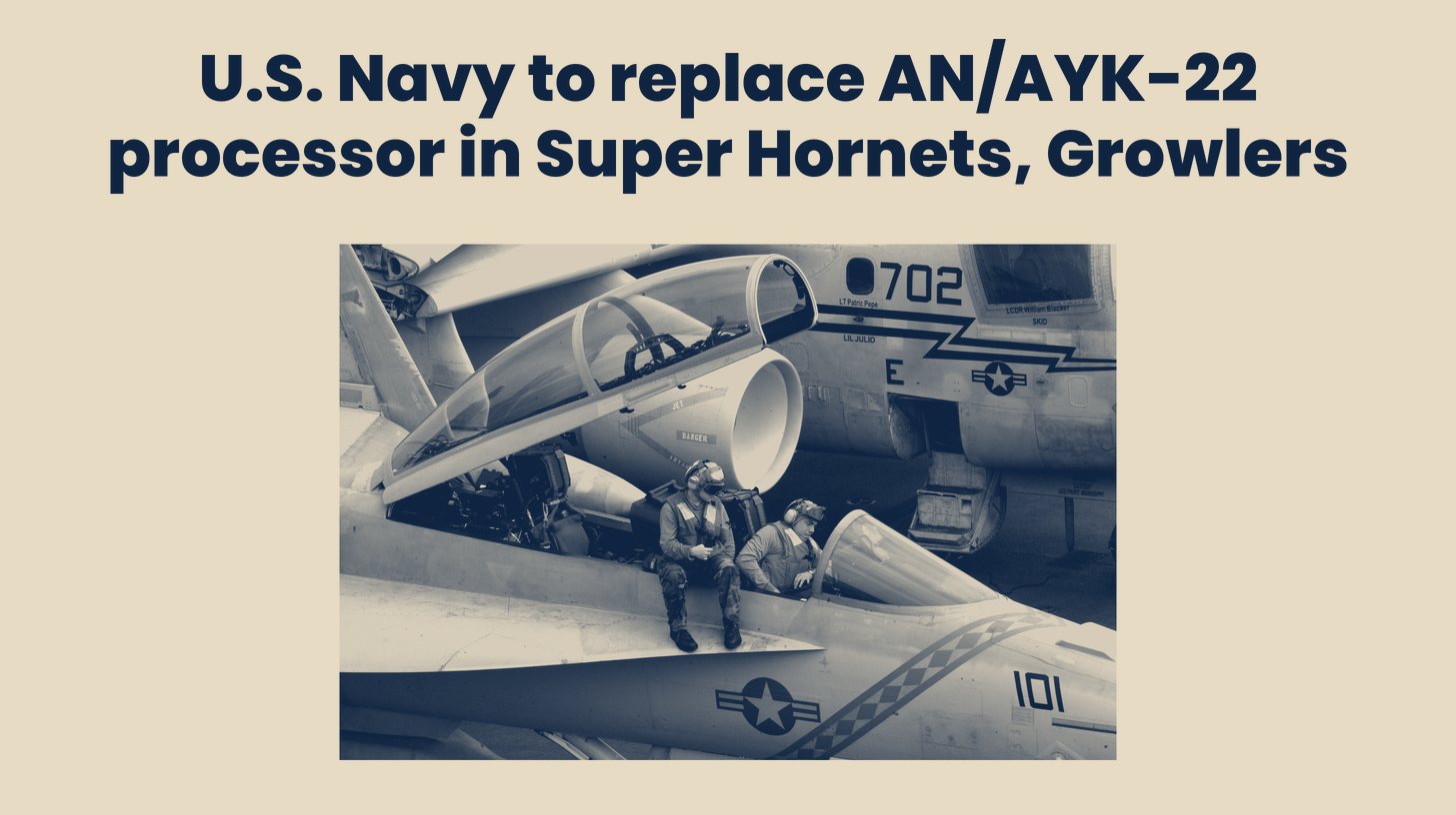 Two-tone 2004 U.S. Navy photo of two aviation electronics technicians running avionics checks while seated on an F/A-18F Super Hornet, not showing the AN/AYK-22 processor itself, set below the headline "U.S. Navy to replace AN/AYK-22 processor in Super Hornets, Growlers."